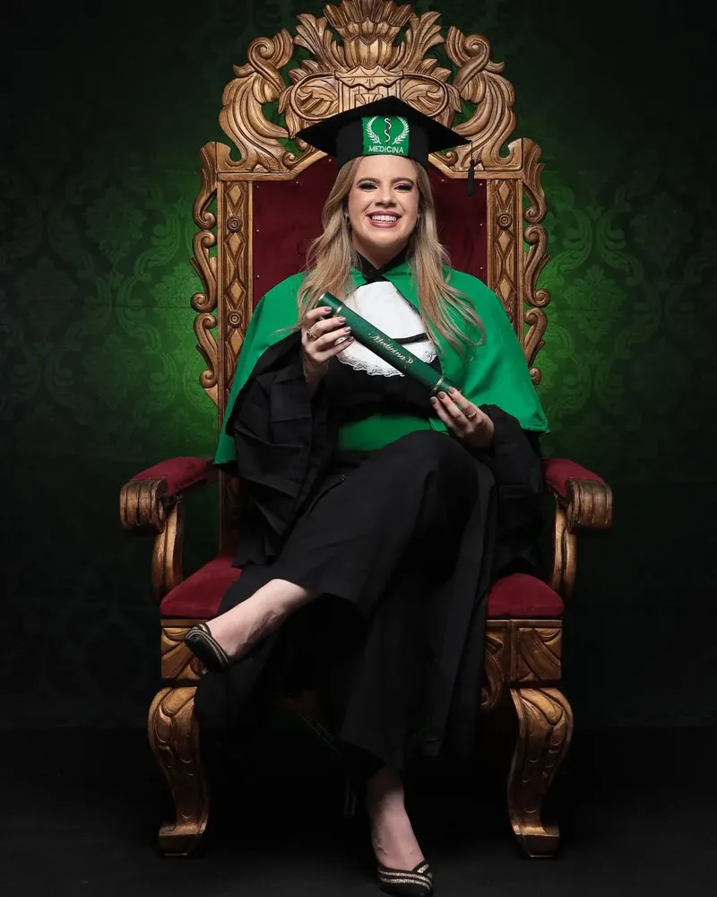 Dra. Alexia Pinto celebra formatura em medicina com beca e diploma solenes.